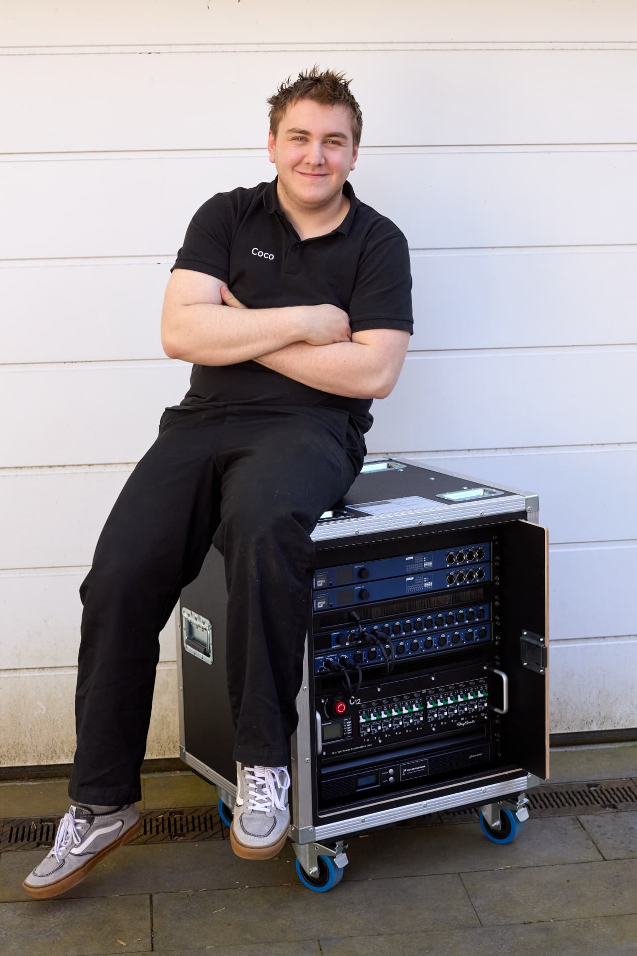 Techniker von COLIGHT&SOUND an einem Technikrack mit Stromverteiler und Netzwerktechnik